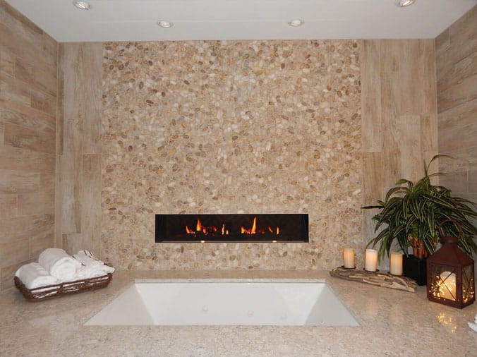 Bathtub with tile wall and built-in gas fireplace